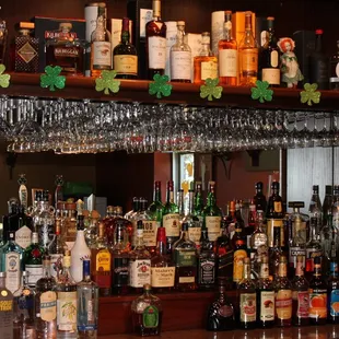 a shelf of liquor bottles and glasses