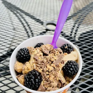 a bowl of yogurt topped with chocolate and blackberries