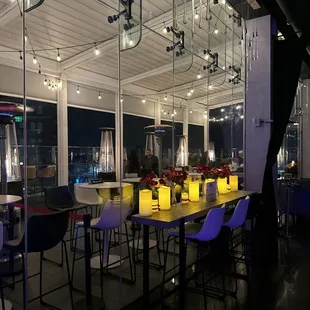 a dining room with a view of a city at night