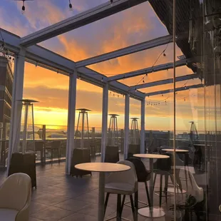 the sun setting over a rooftop restaurant