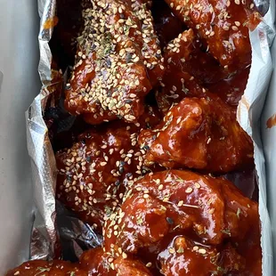 a tray of baked wings with sesame seeds