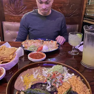 a man sitting at a table with a plate of food