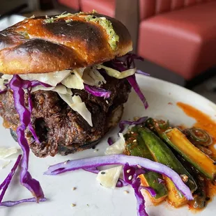 a pulled pork sandwich with coleslaw and asparagus