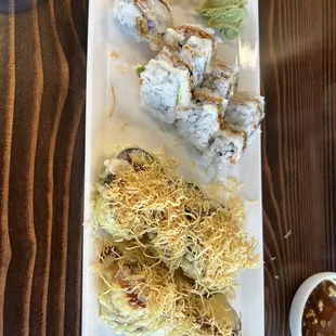 a plate of sushi rolls and a bowl of sauce