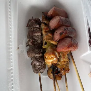 skewered meat and vegetables in a styrofoam container