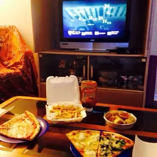 To go order of pizza slices: two cheese on the left and veggie slice and white pizza on the right with French fries and garlic knots