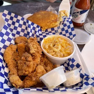 a basket of fried chicken and macaroni and cheese