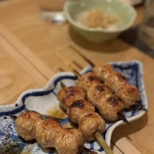 skewered meat on a plate with chopsticks
