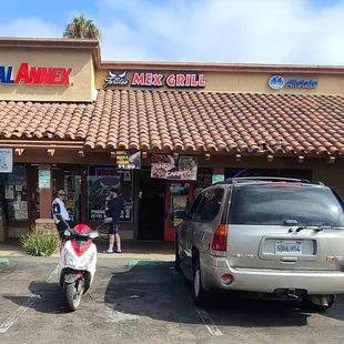 a man on a moped in front of a restaurant