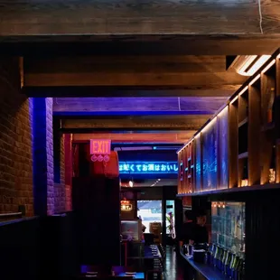 a dimly lit restaurant with neon signs