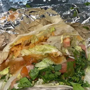 Flour tacos with rice, beans, lettuce, cilantro, and tomatoes