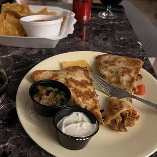 Chips and salsa roja. Regular quesadilla with chicken with the sour cream and pico de gallo to go with. One slice is enough!