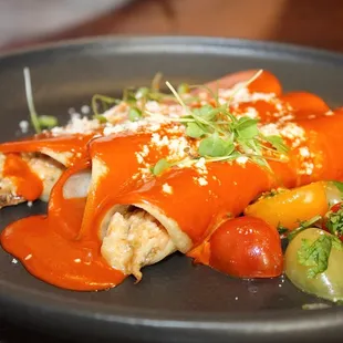 The Enchiladas Rojas are made with corn tortilla, chicken, crema, salsa roja &amp; chihuahua cheese.