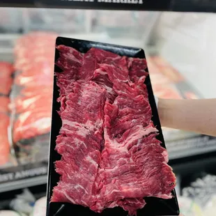 a hand holding a piece of meat