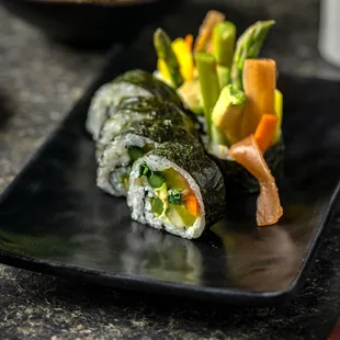 a plate of sushi and vegetables