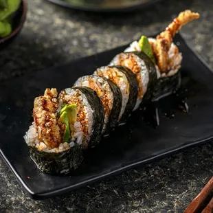 a plate of sushi and chopsticks