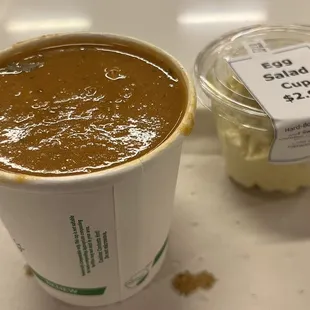 a cup of coffee and a container of sauce