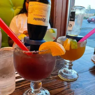 a woman sitting at a table with drinks