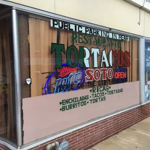 a storefront window with neon signs