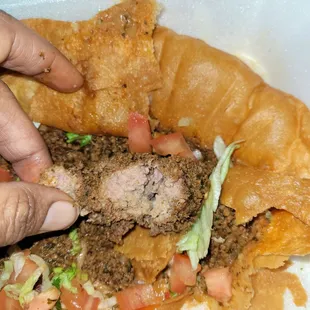 a person grabbing a piece of food out of a styrofoam container