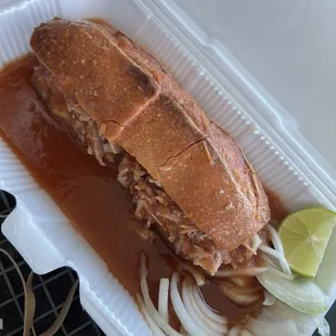 a sandwich with onions and a lime