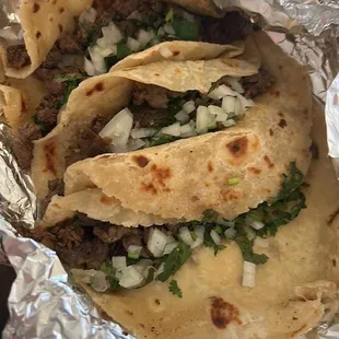 Tacos with beef fajita, cilantro, and onion