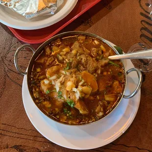 a bowl of soup and a plate of tortillas