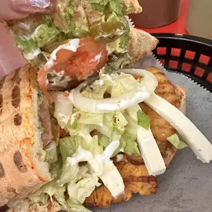 a hand holding a sandwich