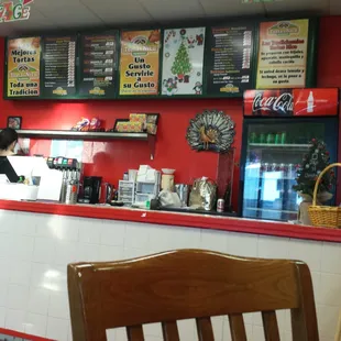 a restaurant counter with menus on the wall