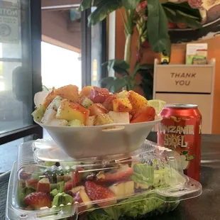 a bowl of salad and a can of soda