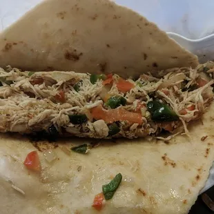Chicken burrito with peppers, onions and tomatoes.