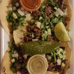 Order of taquitos de asada with cilantro, onion and cucumber