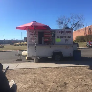 a food cart with a red umbrella