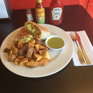 Delicious breakfast burrito with a side of green salsa