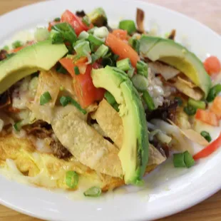 Carnita Ranchera - House Specialty: Open-faced omelet topped w/hash browns, tomatoes, fried corn chips, shredded brisket, cheese &amp; garnish.