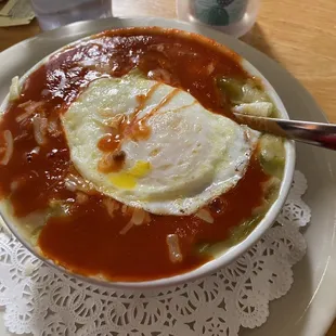 Bowl of red and green chile with an egg