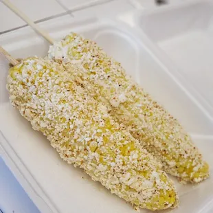 corn on a stick in a styrofoam container