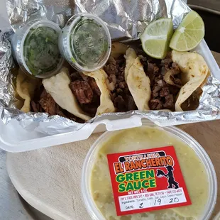 Fajita and Barbacoa Tacos with a container of Green salsa (Hot)