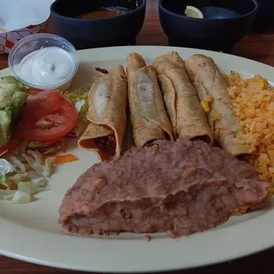 Flautas de pollo con arroz y frijoles.