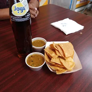 Complimentary homemade corn chips, grilled jalapeño salsa, and apple soda.