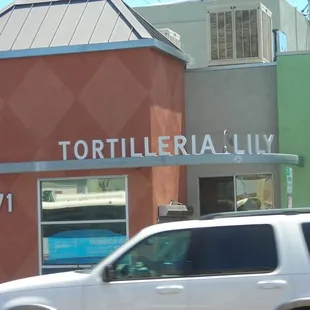 a white van driving past a colorful building