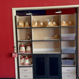 a red wall with shelves and a chair