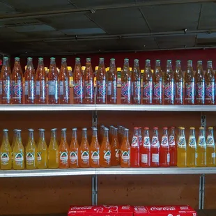 a shelf full of bottles of soda