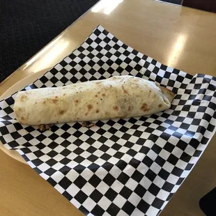 a tortilla on a checkered napkin