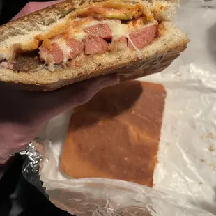 a hand holding a sandwich