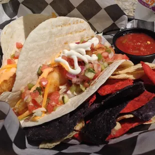 Rockfish Tacos with cabbage, cheese, and sour cream.  Side of chips.