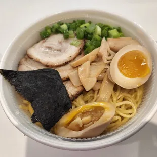 a bowl of ramen noodles with a boiled egg and broccoli