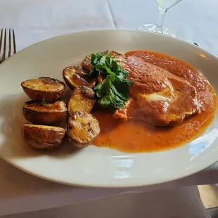 Veal cutlet with roasted potatoes in a red sauce