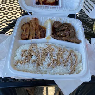 a tray of rice, meat, and fried chicken