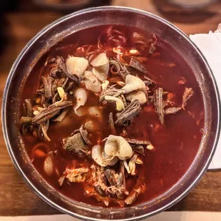 a bowl of soup and chopsticks